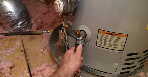 Image: a person doing a water heater flush.