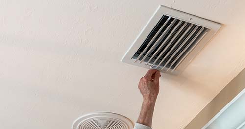 Image: a person opening their air vent.