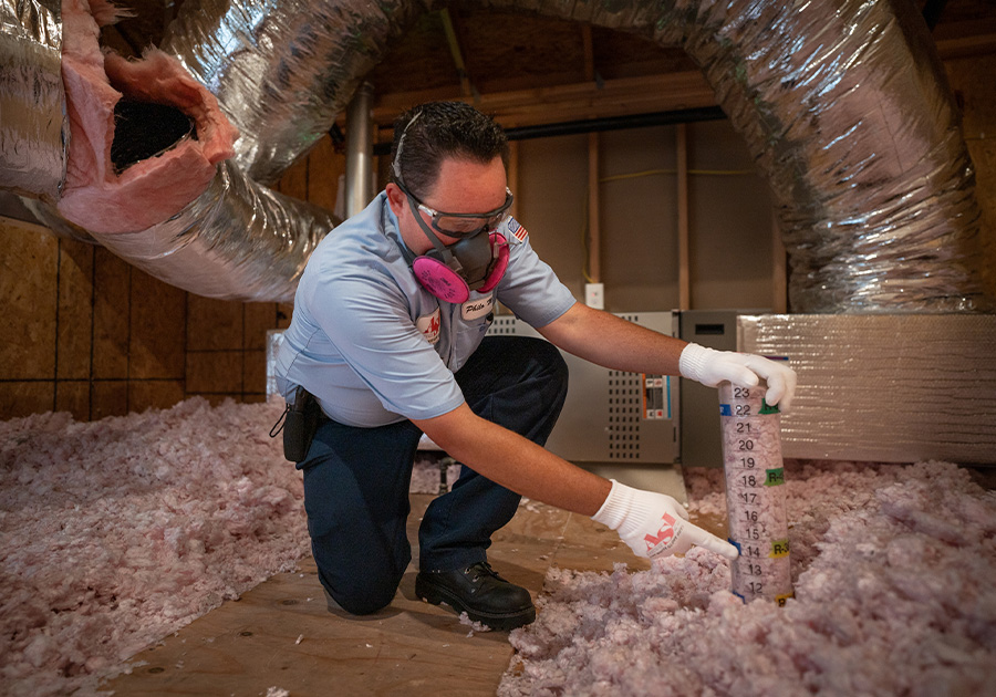 A Insulation expert measuring the amount needed for an attic.